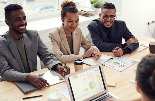 coach photo-of-three-people-smiling-while-having-a-meeting